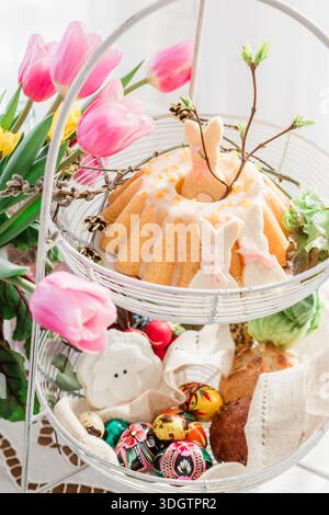 Pane Babka - torta di Pasqua al tavolo festivo con fiori freschi a casa in Polonia Foto Stock