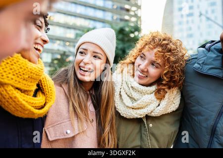 Felici giovani studenti multirazziali che sorridono insieme all'aperto in inverno Foto Stock