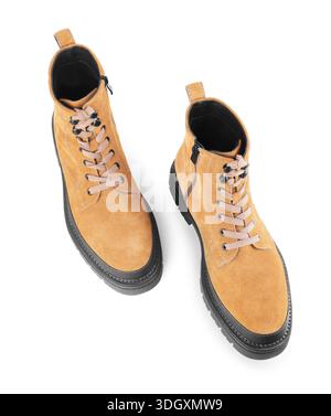 Vista dall'alto degli eleganti stivaletti in pelle scamosciata beige con suola nera e spessa isolata su sfondo bianco. Calzature autunnali unisex casual con lacci e zip. Foto Stock