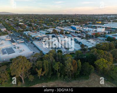 Melbourne, Victoria, Australia. 2 gennaio 2026. - Un drone aereo cattura edifici commerciali, case residenziali e vasti alberi verdi in un sobborgo Foto Stock