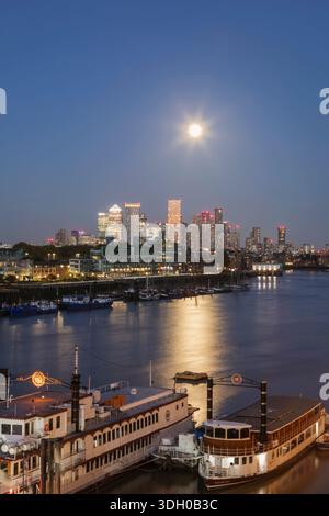 Inghilterra, Londra, Full Moon Over Docklands e Canary Wharf Skyline di notte Foto Stock