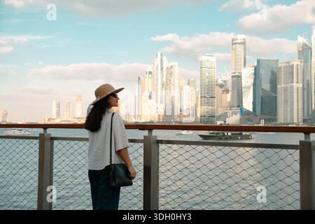 Skyline di Dubai Marina all'ora d'oro con un turista che guarda il tramonto Foto Stock
