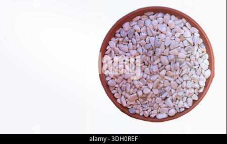 Pietra decorativa bianca nella ciotola rotonda su sfondo bianco vista dall'alto Foto Stock