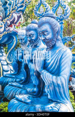 Thailand Blue Temple Wat Rong Suea Ten a Chiang Rai, febbraio 2025. Fila di statue di monaci dipinte di blu in preghiera al Tempio Blu della Thailandia. Foto Stock