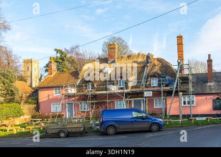 Thatcher at Work sostituendo la dorsale di paglia dell'edificio di pub di campagna con tetto in paglia, Sorrel Horse, Shottisham, Suffolk, Inghilterra, REGNO UNITO Foto Stock