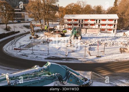 Cantiere innevato con diversi escavatori e un grande edificio sullo sfondo, Nagold, distretto di Calw, Foresta Nera, Germania Foto Stock