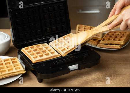 Potrai preparare waffle caldi dorati e dorati da una macchina elettrica in una cucina casalinga Foto Stock
