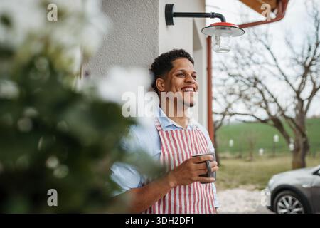 Baker all'aperto, bevendo una tazza di caffè. Foto Stock