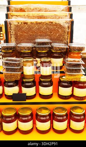 Giusto, supermercato del miele. Apicoltori, vari tipi di miele in vasetti di vetro e altri piatti vari, tra cui favi da miele e miele con noci e graziose api bambole, sono in vendita sugli scaffali. Cibo sano. Foto Stock