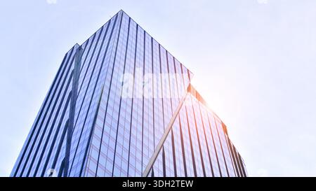 Moderno edificio di uffici esterno realizzato in vetro e acciaio. Finestre dell'edificio per uffici. Concetto architettonico astratto con luce solare. Foto Stock