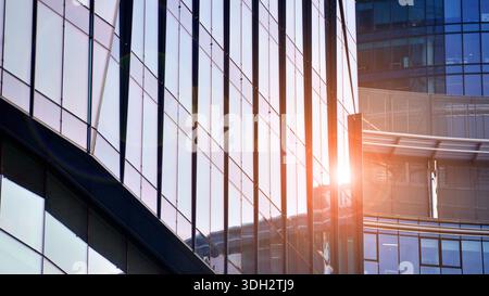 Moderno edificio di uffici esterno realizzato in vetro e acciaio. Finestre dell'edificio per uffici. Concetto architettonico astratto con luce solare. Foto Stock