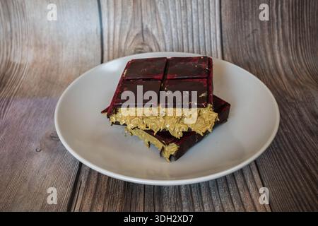 Sweet Dubai Chocolate Bar su piatto bianco. Dolce Choco alla moda con ripieno di pistacchio e Kadayif. Foto Stock