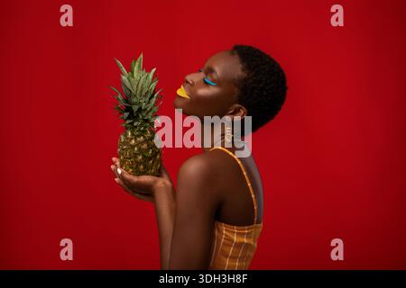 Ritratto del profilo di donna afroamericana con ananas Foto Stock