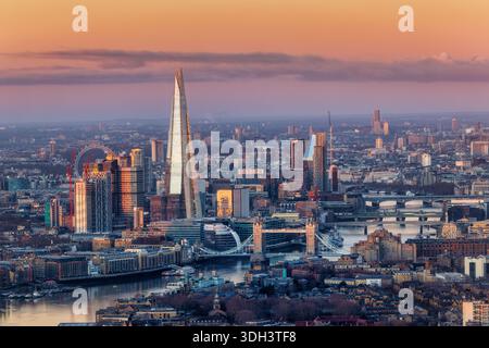 Vista sopraelevata dello skyline della città di Londra con il Tower Bridge und Shard Building che riflette la prima luce del sole durante una fredda alba invernale Foto Stock