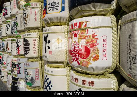 ISE, Giappone - 29 ottobre 2023: Vista ravvicinata di botti di sake dipinte impilate con scritte giapponesi, illustrazioni colorate e legature di corda esposte all'aperto. Foto Stock