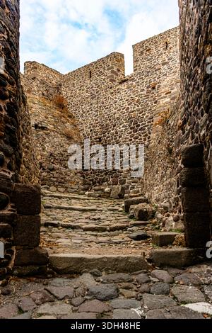 Myrina, Grecia - 22 ottobre 2025: Antiche mura in pietra e stretto sentiero all'interno della fortificazione medievale del Castello di Myrina. Foto Stock