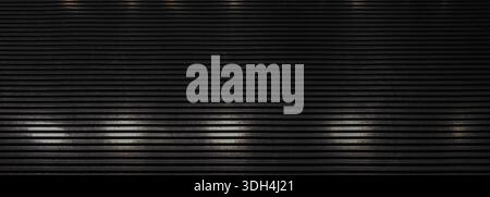 Sfondo in acciaio industriale scuro con motivo orizzontale ripetitivo con sottili riflessi metallici. Una texture moderna ed elegante, ideale per l'arco Foto Stock