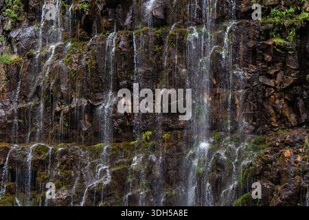 Una splendida cascata si estende su rocce coperte di muschio a Trialeti, Georgia, incarnando la serena bellezza dell'autunno. Il flusso delicato contrasta con Foto Stock