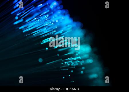 Un'immagine astratta che mostra fibre luminose crea un effetto dinamico e futuristico su uno sfondo scuro. Foto Stock