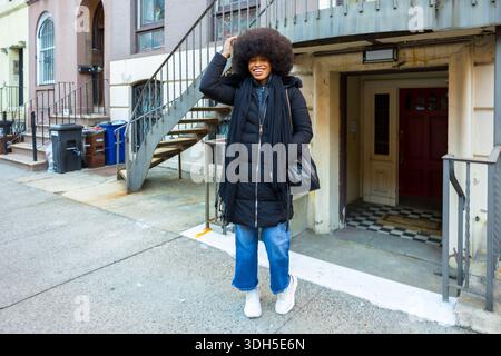 Giovane donna felice che posa per New york City Street Foto Stock