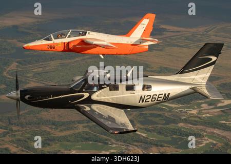 Due aeromobili che operano insieme in volo consistono in un Piper PA-46-600TP M600 turboelica immatricolato come N26EM con numero di serie del costruttore 4698081 e un addestratore a getto SIAI-Marchetti S-211 registrato come N123W con marchio di stile militare 386 e numero di serie 010/02-007. L'immagine mostra una vista ravvicinata dal punto di vista del pilota, mentre entrambi gli aeromobili volano in formazione coordinata durante una sessione di fotografia aria-aria. La scena fu registrata al Sun N Fun Aerospace Expo tenutosi in Florida nel 2025 in condizioni di luce diurna con entrambi gli aerei visibili in volo. Foto Stock