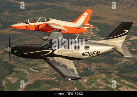 Due aeromobili che operano insieme in volo consistono in un Piper PA-46-600TP M600 turboelica immatricolato come N26EM con numero di serie del costruttore 4698081 e un addestratore a getto SIAI-Marchetti S-211 registrato come N123W con marchio di stile militare 386 e numero di serie 010/02-007. L'immagine mostra una vista ravvicinata dal punto di vista del pilota, mentre entrambi gli aeromobili volano in formazione coordinata durante una sessione di fotografia aria-aria. La scena fu registrata al Sun N Fun Aerospace Expo tenutosi in Florida nel 2025 in condizioni di luce diurna con entrambi gli aerei visibili in volo. Foto Stock