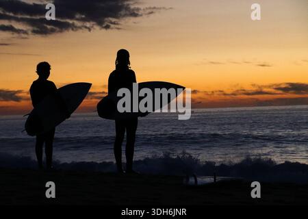 I surfisti al tramonto Foto Stock