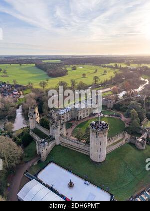Vista aerea delle antiche mura di pietra del castello di Warwick che abbracciano prati color smeraldo, giustapposte al tortuoso fiume Avon e ai campi lontani, Warwick, Foto Stock