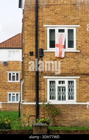 Bandiera di St Georges appesa alla finestra di un appartamento a Bromley, nel sud di Londra. Foto Stock