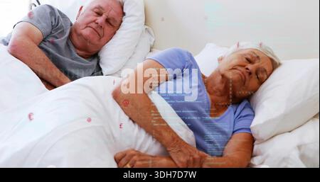 La coppia senior che dorme indossa la parte superiore azzurra, il tee grigio in camera da letto e mostra un anello dorato sulla coperta Foto Stock