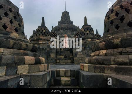 Visitatrice donna tra gli antichi Stupa buddisti a Borobudur, Indonesia Foto Stock