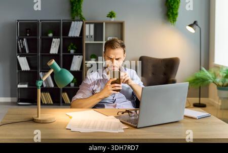 Stress di un uomo d'affari che legge notizie di crisi cattive sullo schermo dello smartphone Foto Stock