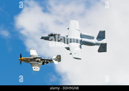 USAF A-10 Thunderbolt II e P-51D Mustang 'Bald Eagle' 44-73029 in un volo di formazione storica contro il cielo blu. Iconico velivolo moderno e della seconda guerra mondiale. Foto Stock