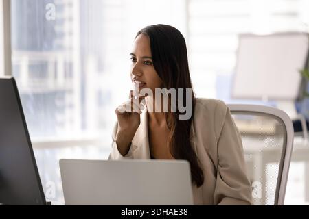 Donna profondamente pensata, mentre lavora al computer Foto Stock