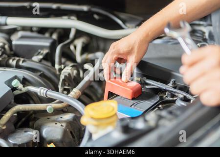 Meccanico che ripara un'auto a casa. Riparazione e assistenza. Il meccanico apre il cofano del veicolo controllando la funzione Auto Mobile. Foto Stock