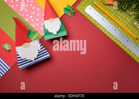 Sfondo fai da te con gnomi di carta fatti a mano e strumenti artigianali. Concetto di officina con posa piatta. Inserire il testo. Foto Stock