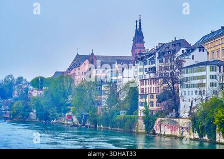 La vista sulla riva del fiume Reno con storiche case residenziali e guglie di Basilea Minster sullo sfondo, Svizzera Foto Stock