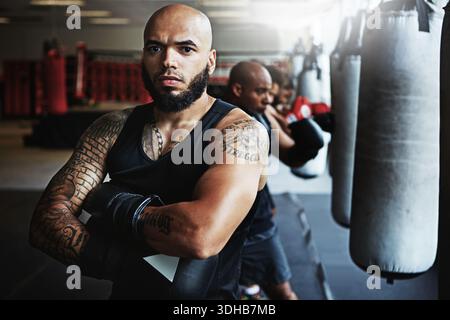 Ritratto, pugile e uomo con sicurezza per lo sport, il fitness o allenatori determinati in palestra per il combattimento. Allenatore di pugilato, atleta e persona seria con Foto Stock
