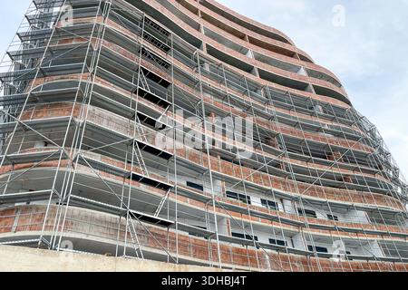 Edificio in costruzione con ponteggio, vista sul cantiere di un edificio a più piani Foto Stock