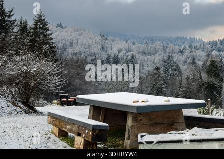 tavolo da picnic coperto di neve nel paesaggio montano invernale Foto Stock