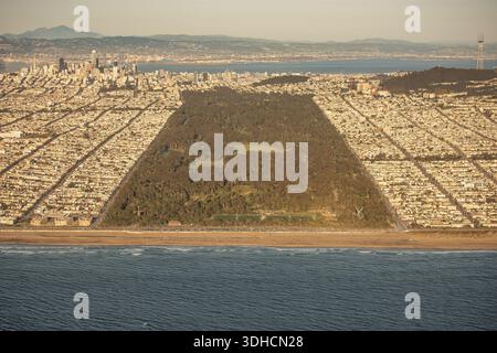 Vista aerea della vasta e verdeggiante distesa del Golden Gate Park che si estende verso il lontano paesaggio urbano, delimitato dall'abbraccio blu del Pacifico, San fra Foto Stock