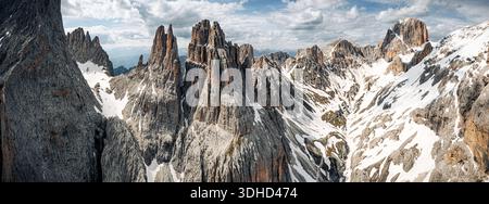 Vista aerea del Catinaccio d'Antermoia e delle torri Vajolet le vette si innalzano in netto contrasto con la neve che si scioglie, dipingendo un paesaggio spettacolare di roccia Foto Stock