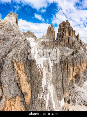 Veduta aerea delle torri Vajolet cime che perforano il cielo, spolverato di neve contro l'aspra parete rocciosa, una sinfonia di grigio e bianco, Val di Fassa, Trentino Foto Stock