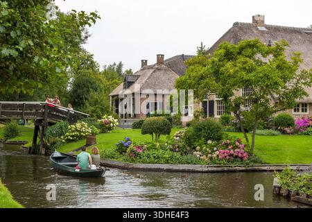 GIETHOORN, PAESI BASSI - AGOSTO 01 2017: Visitatori sconosciuti nel giro turistico in barca in un canale a Giethoorn. Le belle case e il giardinaggio Foto Stock