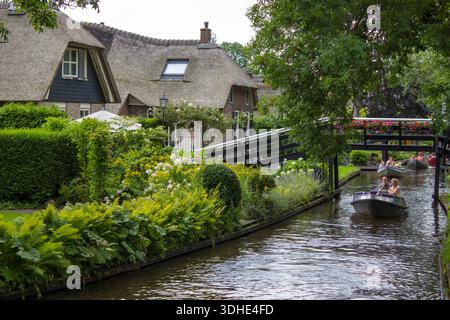 GIETHOORN, PAESI BASSI - AGOSTO 01 2017: Visitatori sconosciuti nel giro turistico in barca in un canale a Giethoorn. Le belle case e il giardinaggio Foto Stock