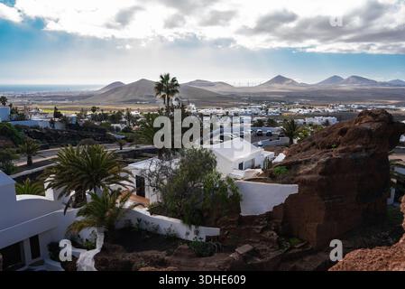 Colline vulcaniche di Lanzarote, ville bianche, palme e turbine eoliche Foto Stock
