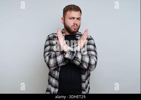 Uomo in camicia a quadri che fa un gesto X con le braccia Foto Stock