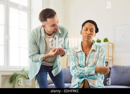 L'uomo si scusa per sconvolgere la moglie o la fidanzata durante un conflitto di relazioni a casa Foto Stock