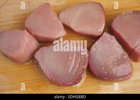 Pesce fresco tagliato a pezzi su un asse di legno Foto Stock