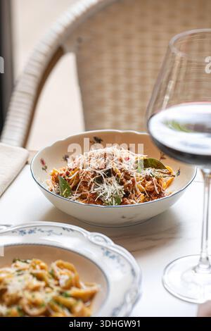 Spaghetti bolognesi serviti con vino rosso Foto Stock